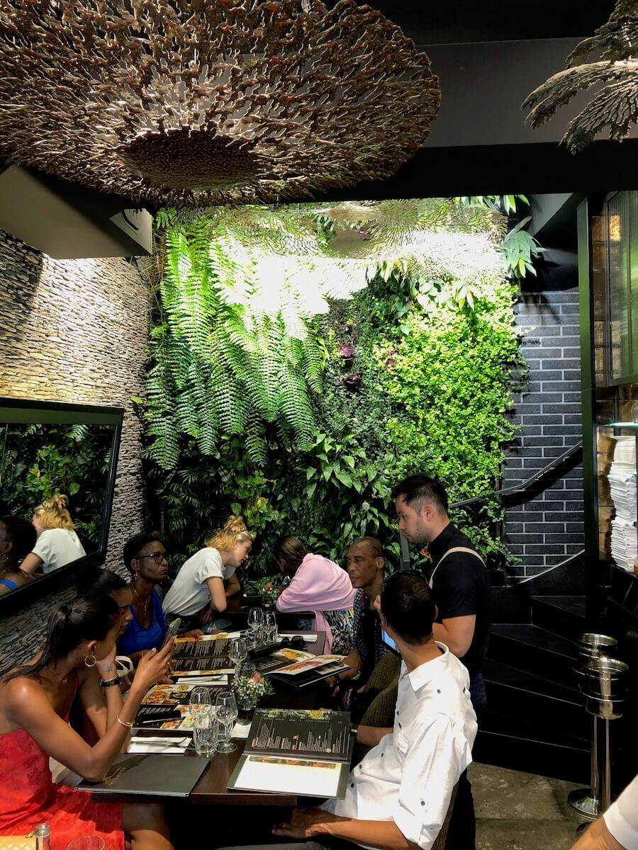 petit restaurant avec un mur végétal au fond